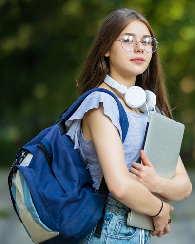 cheerful-attractive-young-woman-with-backpack-notebooks-standing-smiling-park